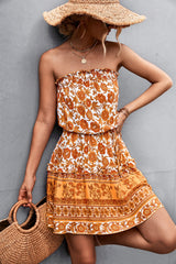Donna con abito estivo floreale arancione, cappello di paglia e borsa intrecciata. Moda estiva, abbigliamento casual elegante.